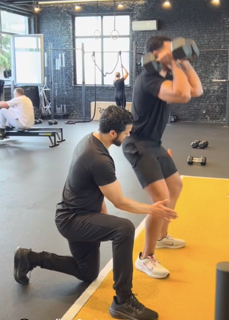 Coach DM corrige un mouvement pendant une séance de personal training chez Reasfit Vilvoorde